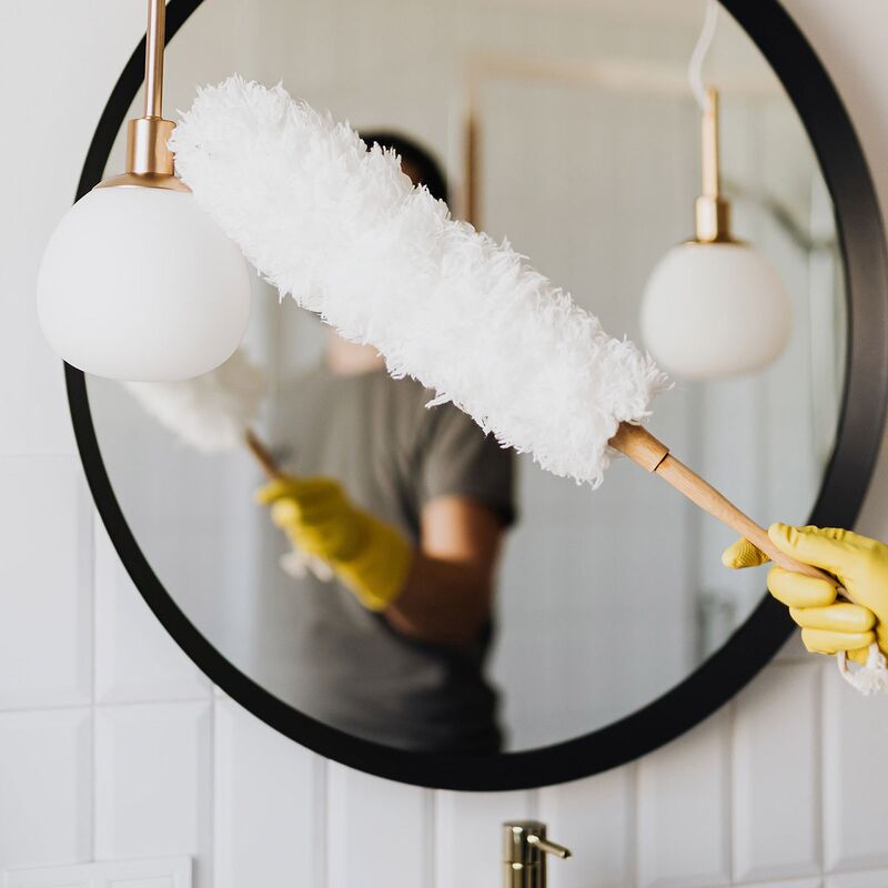 Weibliche Reinigungskraft mit Staubwedel